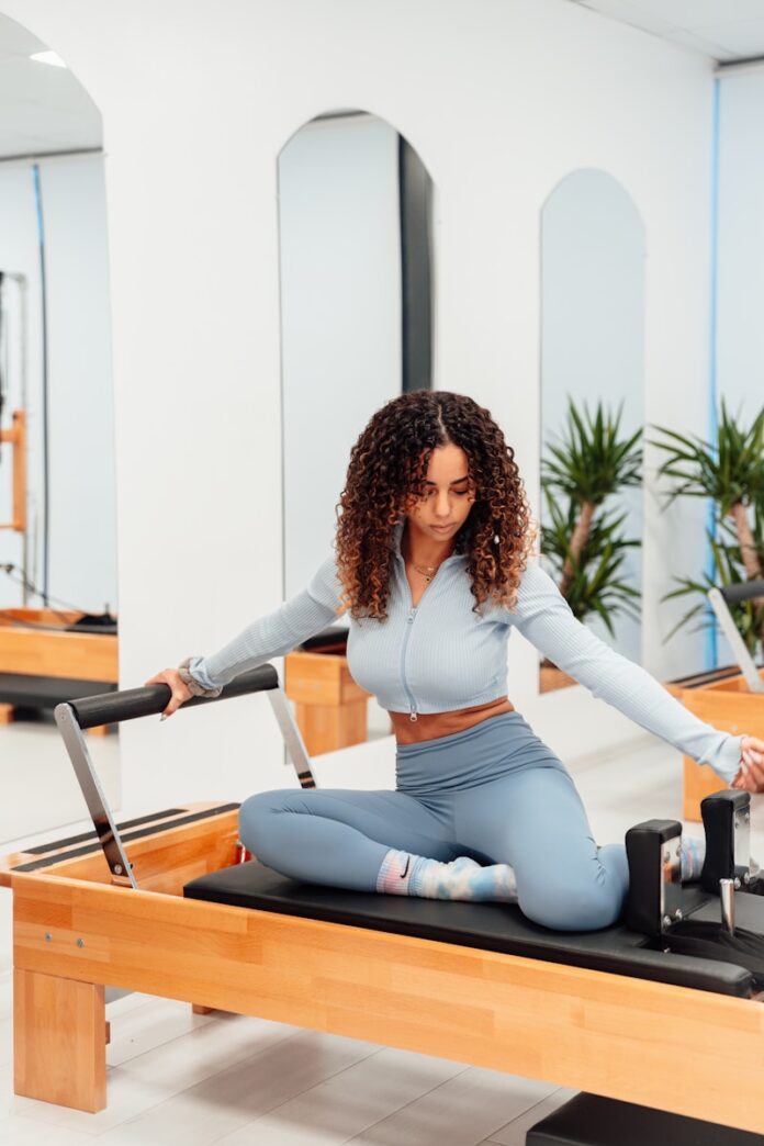 a woman sitting on a piyor in a gym