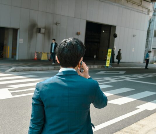 바쁜 직장인을 위한 건강 관리법, 작은 습관이 큰 변화를 만든다 A businessman talks on the phone while crossing the street.