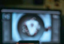 AI 기반 건강 관리, 개인 맞춤형 의료 혁신 이끈다 a person holding a cell phone in front of a tv