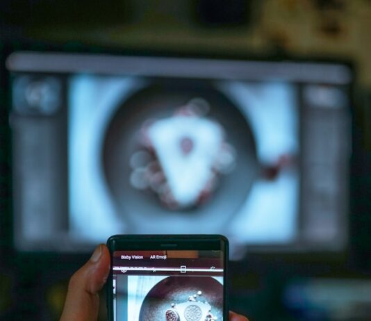 AI 기반 건강 관리, 개인 맞춤형 의료 혁신 이끈다 a person holding a cell phone in front of a tv