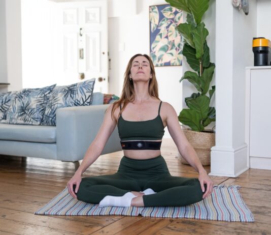 만성 피로를 부르는 ‘숨의 패턴’ 붕괴와 회복의 기술 a woman sitting on a yoga mat in a living room