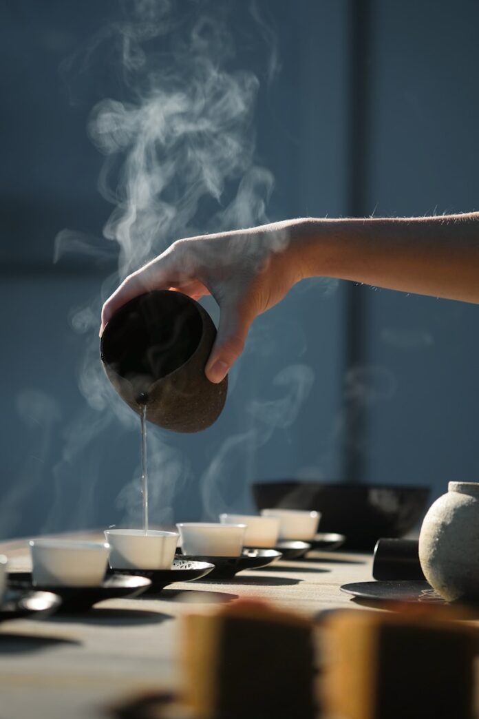 Photo by 五玄土 ORIENTO person pouring hot water on white cup