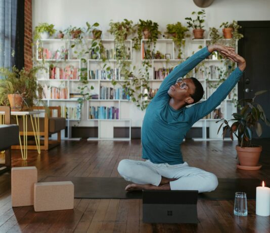 ‘마이크로 운동’ 열풍, 바쁜 일상 속 건강 챙기는 새로운 방법 a man is doing yoga in a living room