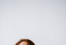 “만성피로, 단순한 피곤함 넘어서 — 최신 연구와 트렌드로 바라본 똑똑한 관리법” a woman sitting on a couch holding her hands to her face