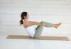 바쁜 일상 속 건강 챙기기, ‘필라테스’가 인기인 이유와 실천법 Woman in boat pose on yoga mat